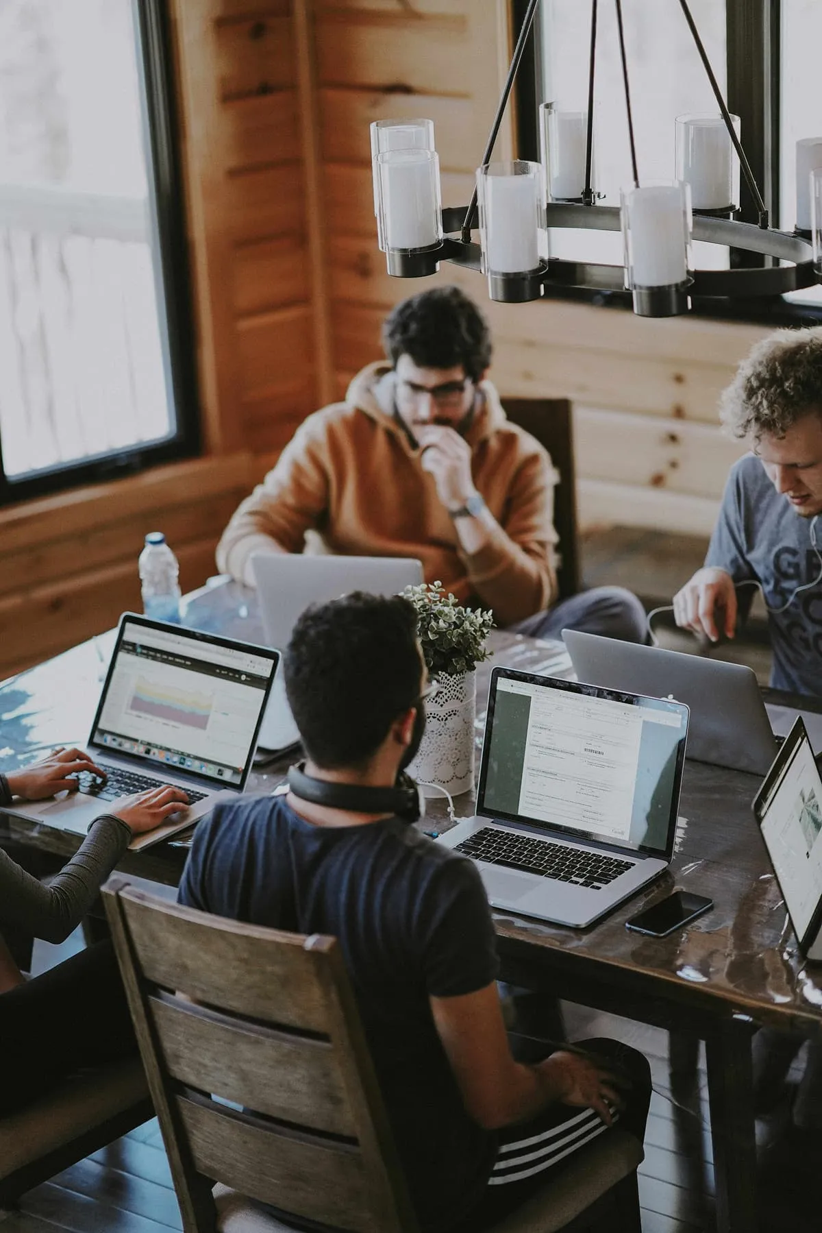 People working together at a desk with computers and notes