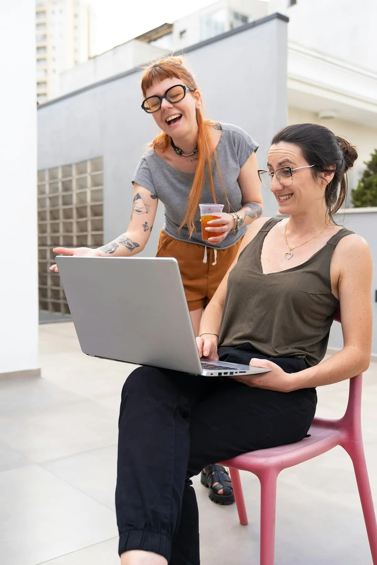 Woman sitting with a laptop and working remotely in a casual environment
